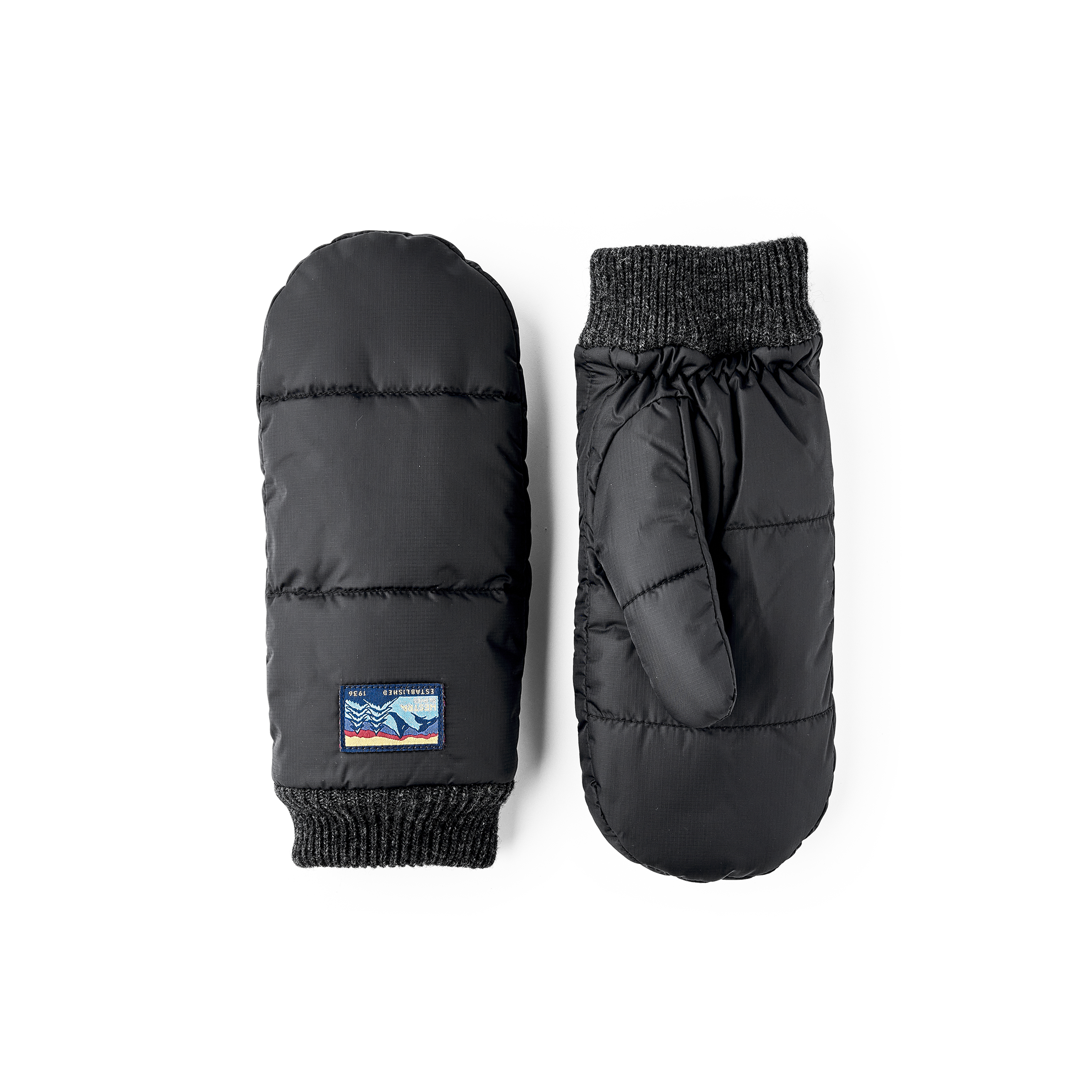 Svart tumhandske i tyg med stickad mudd