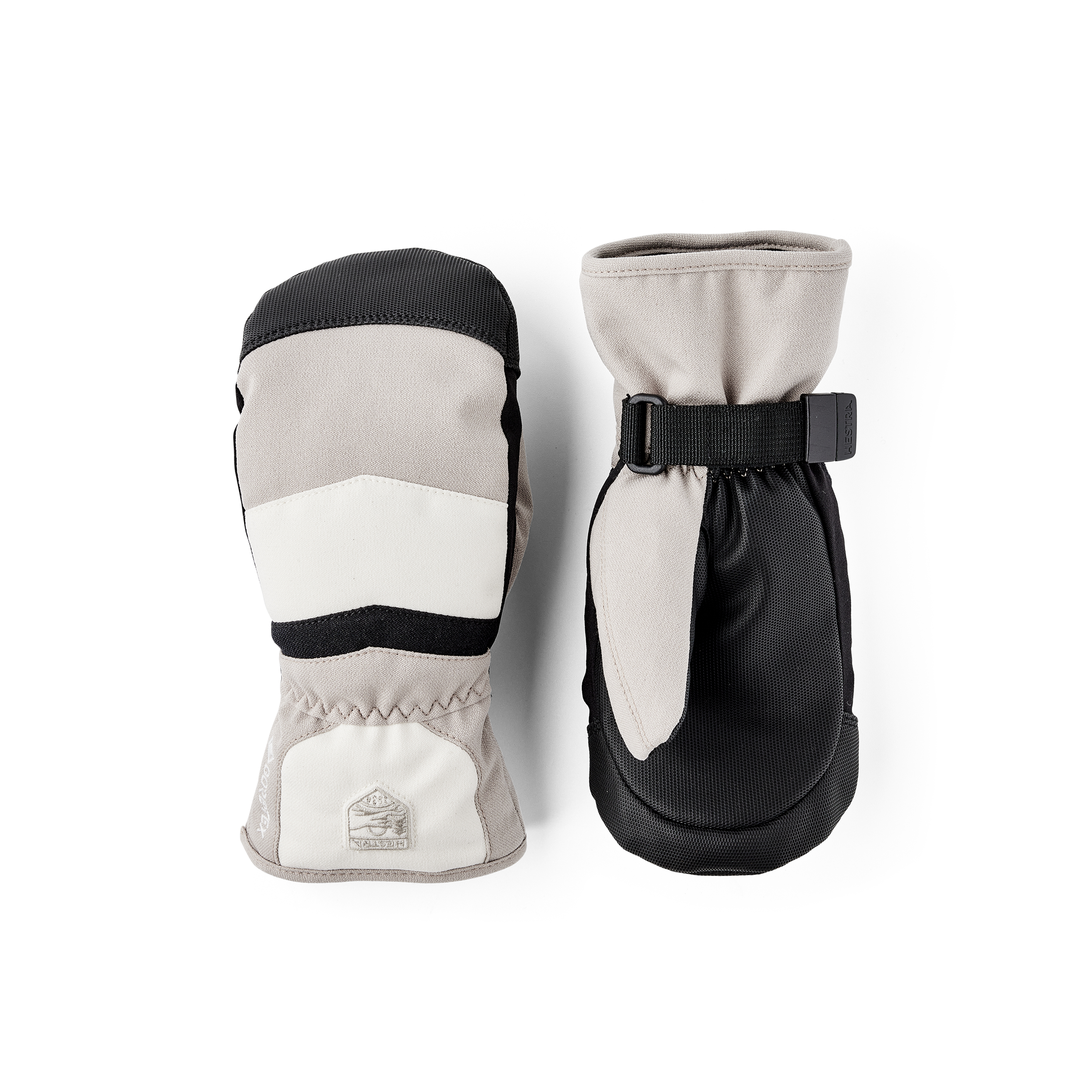 Beige och vit tumhandske i tyg med svart syntetmaterial i innerhanden och handledsjustering