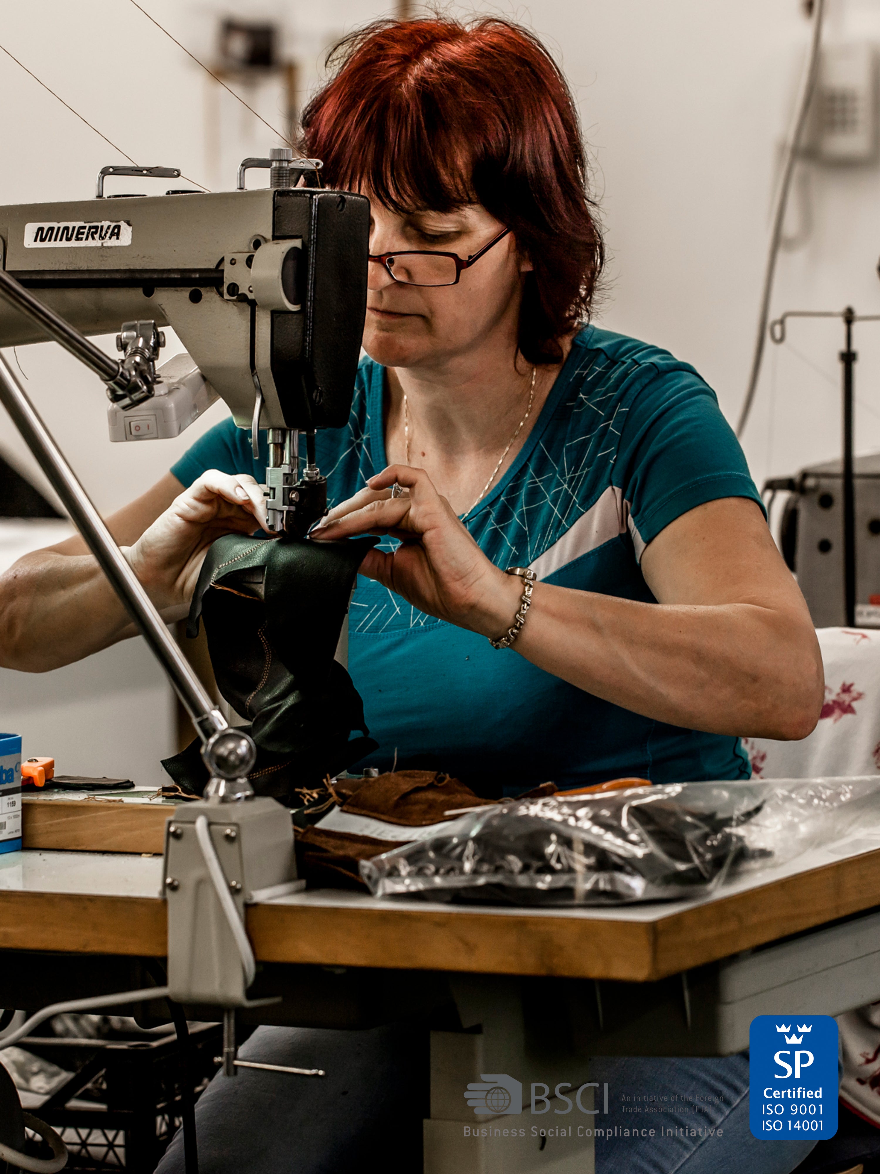 Närbild: en av våra hantverkares händer som syr en skinnhandske i industrisymaskin